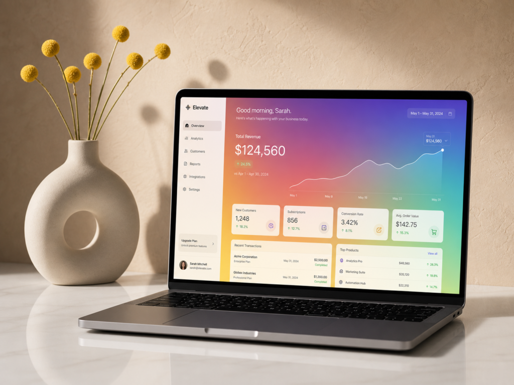 A premium business still life of an open laptop displaying an analytics dashboard with an upward growth curve and a smooth rainbow gradient.